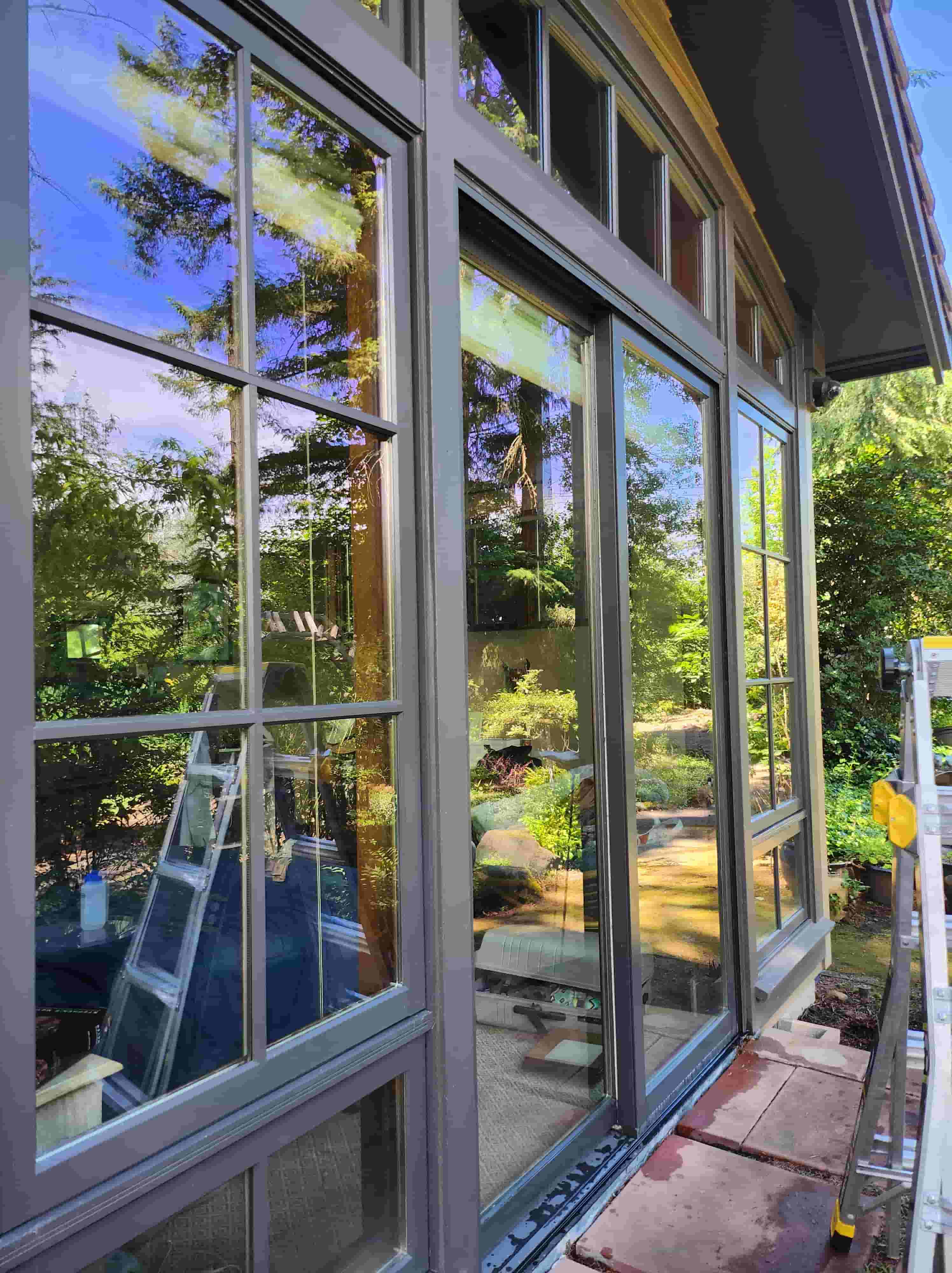 Clean exterior windows on a Portland-area home reflecting fall trees after HomeHaven Northwest service